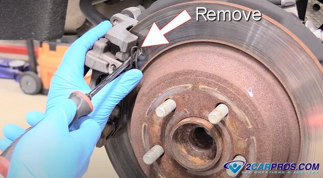 remove rear brake caliper retainer spring